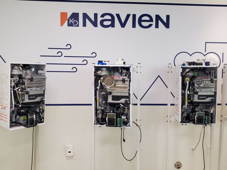 Navien boilers mounted on mobile stands in a training room, illustrating the setup for educational purposes.