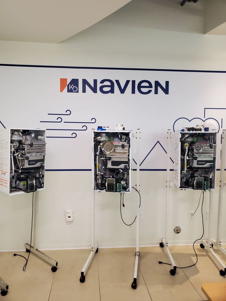 Navien boilers mounted on mobile stands in a training room, illustrating the setup for educational purposes.